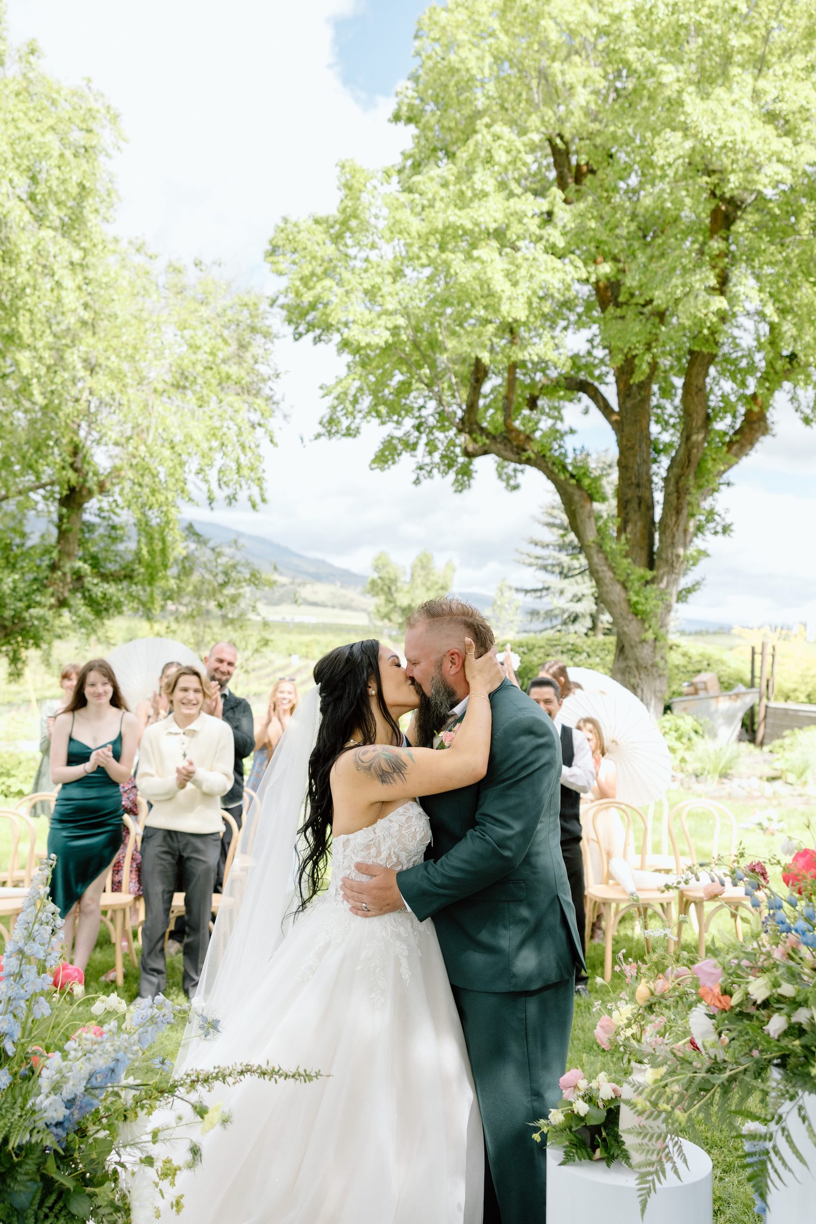 Outdoor ceremony first kiss beneath a large tree at Naumes Suncrest Winery.