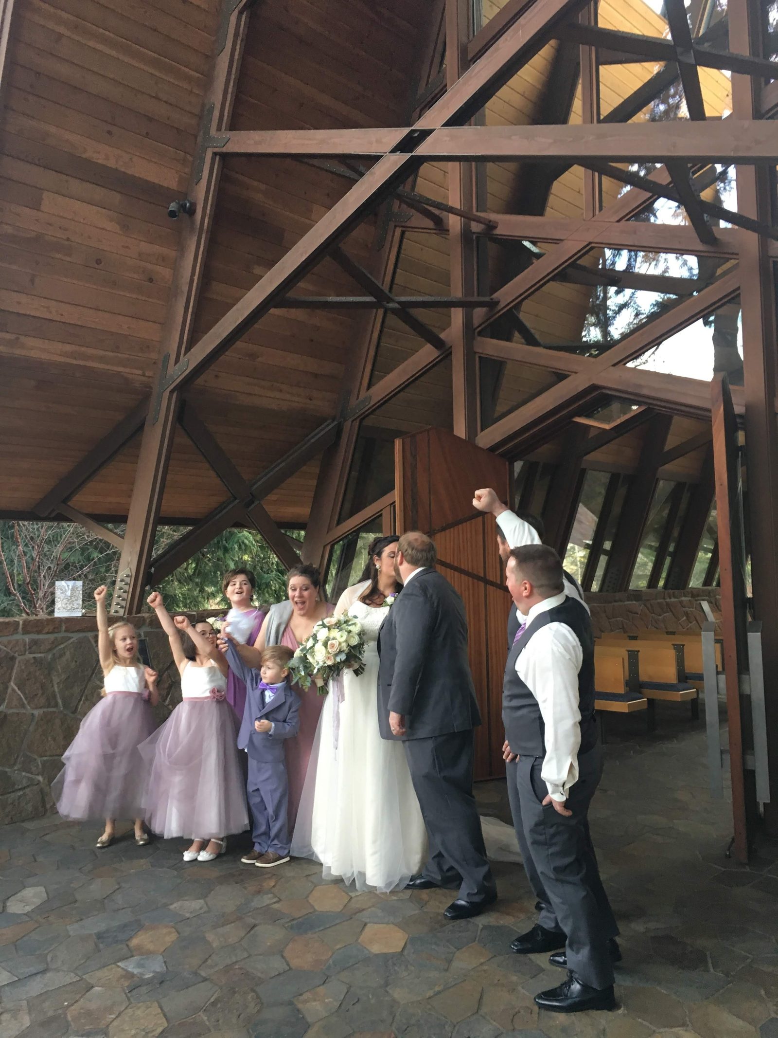Wedding party cheering as a couple kiss inside the Capella by the Sea chapel in Brookings.