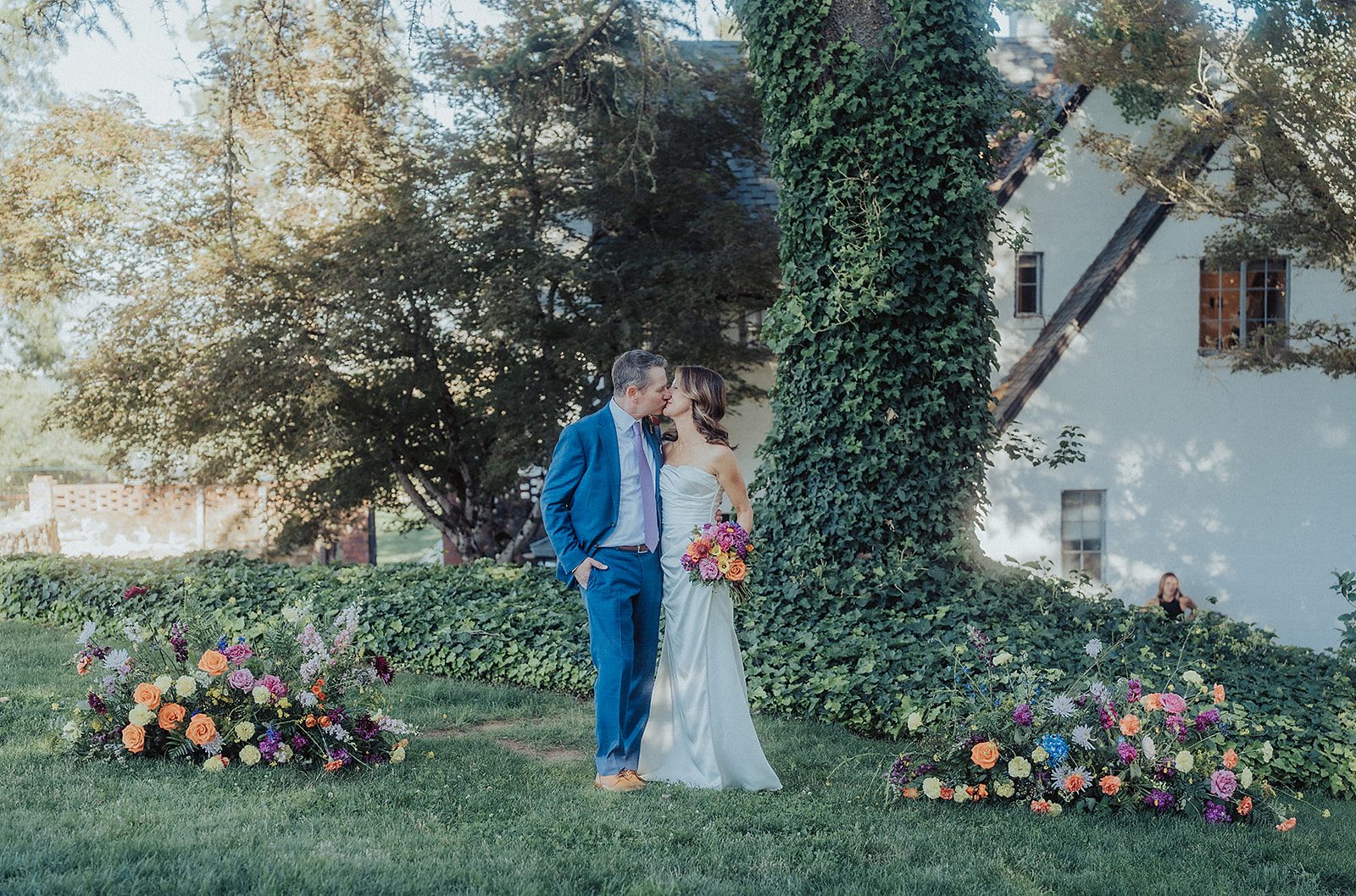 Couple at a vineyard wedding with colorful florals.