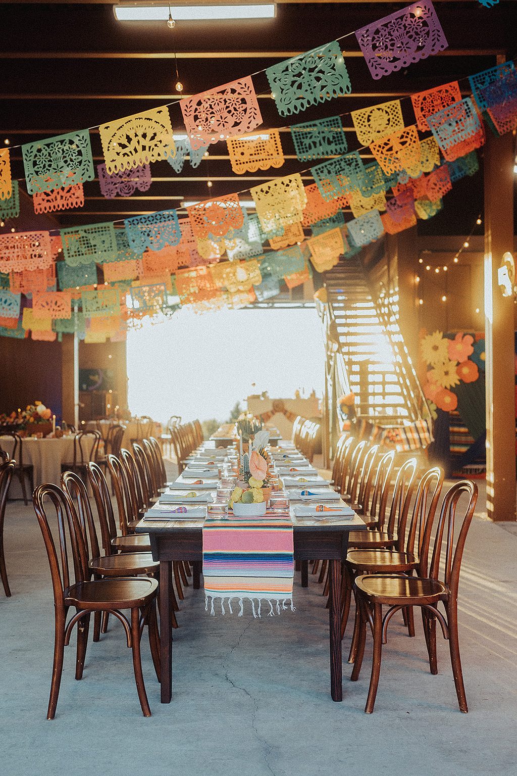 Reception hall strung with colorful papel picado banners.